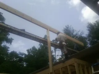 Carpenter setting a ridge beam over a new addition frame — Ice Dam Removal by Roofing Brothers in San Pedro