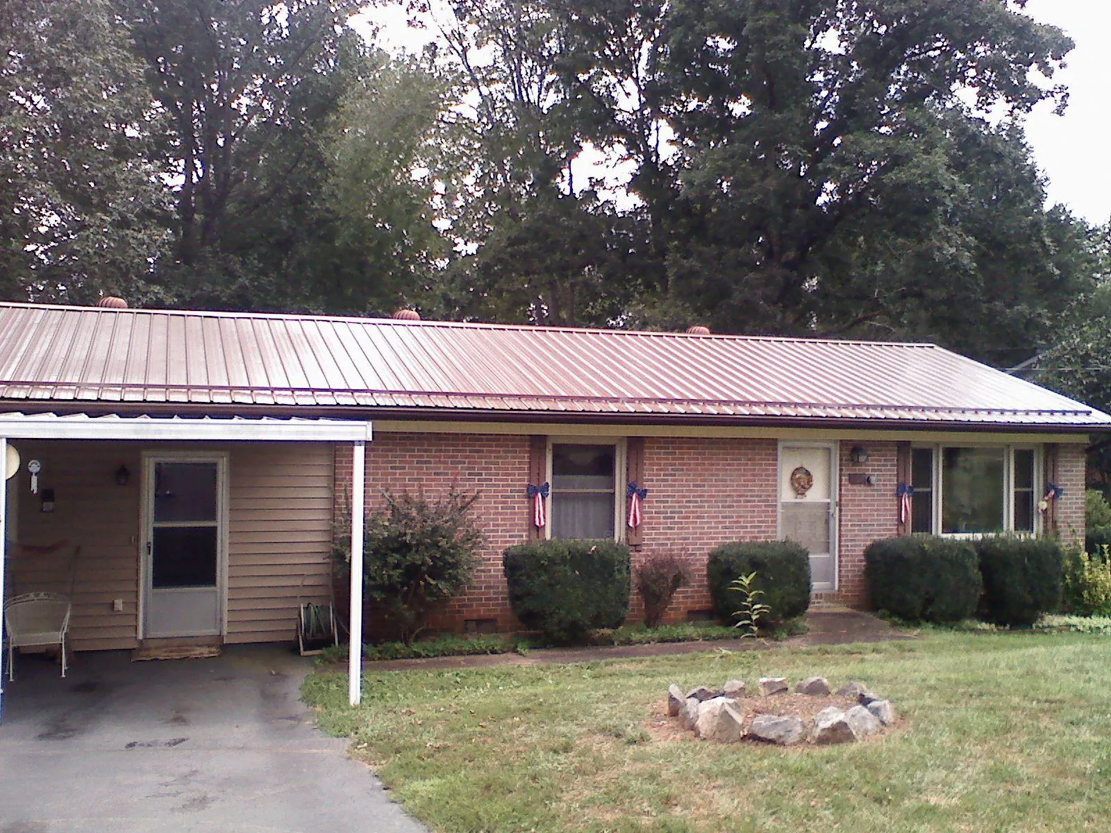 Bronze metal roof and carport on a brick ranch home — Roof Repair work by our crew in San Pedro